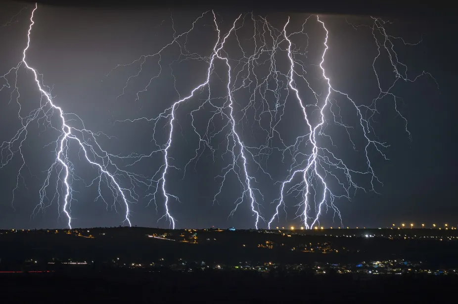 photo of multiple cloud to ground lightning strikes during a nighttime thunderstorm
