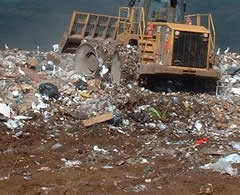 a landfill with a construction vehicle moving garbage