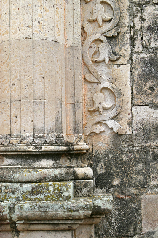 Carvings on the exterior of an old limestone building are decaying due to acid rain.