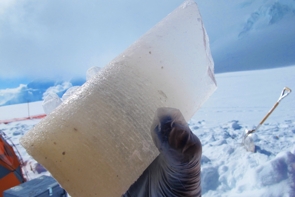 This is an image of a piece of an ice core. The ice is dingy and dirty towards the bottom of the sample and more clear towards the top. 