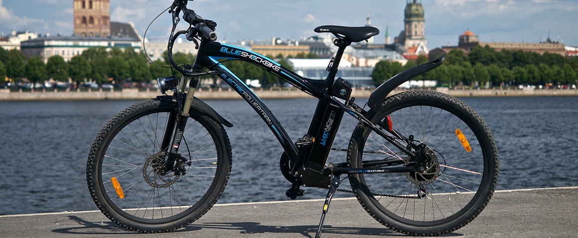 This is an image of an electric bike parked outside alongside a waterway.
