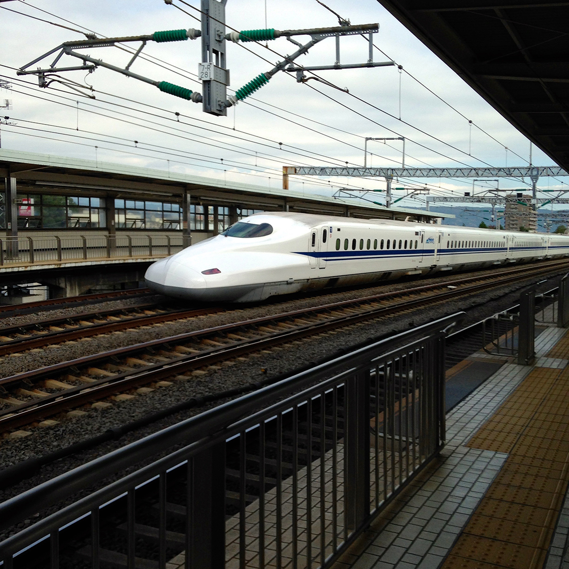 This is an image of a high speed train pulling into a train station.