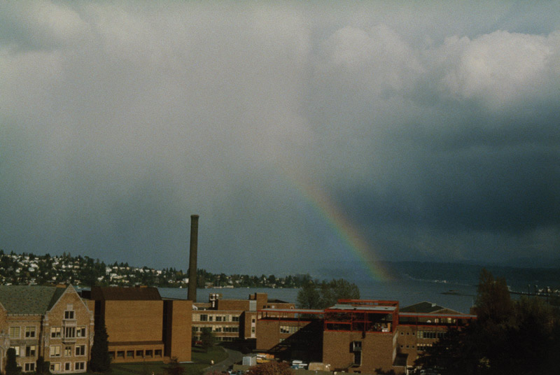 Nimbostratus clouds and a rainbow over a city