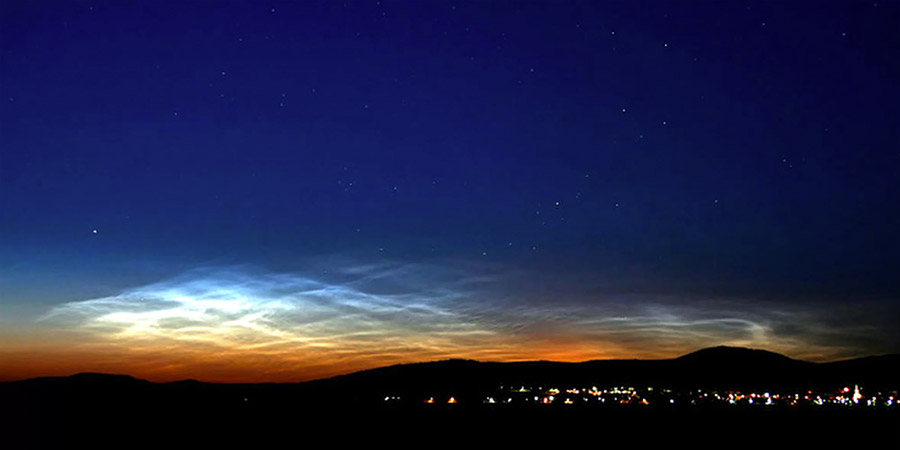 Noctilucent clouds glowing on the horizon just after sunset