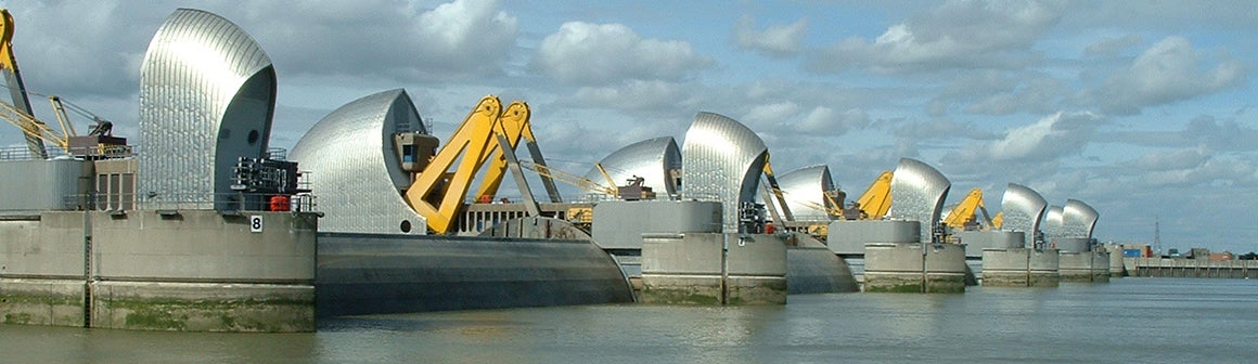 This image shows a large metal barrier across the Thames River in England