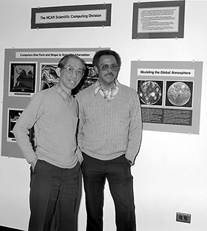 Photograph from 1975 showing Warren Washington and fellow scientist, Akira Kasahara, standing in front of an exhibit on their work in climate modeling.