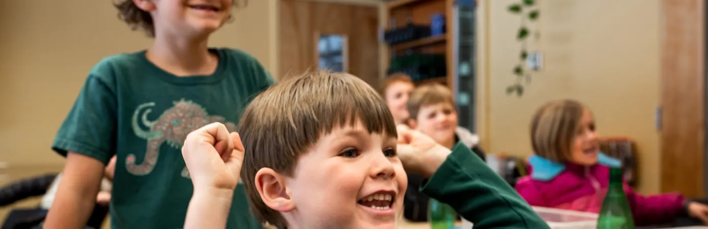 Students in a classroom who are excited by what is going on.