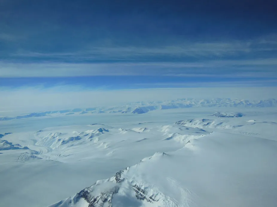 photo of Antarctica showing a large ice sheet and mountains