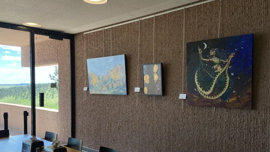 Several pieces of art hung up on the wall in the Mesa Lab Café. 