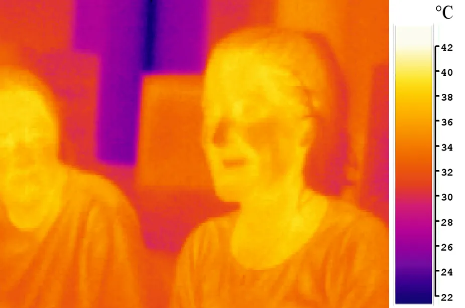 photo of infrared energy showing two students who appear brighter and therefore warmer than their surroundings
