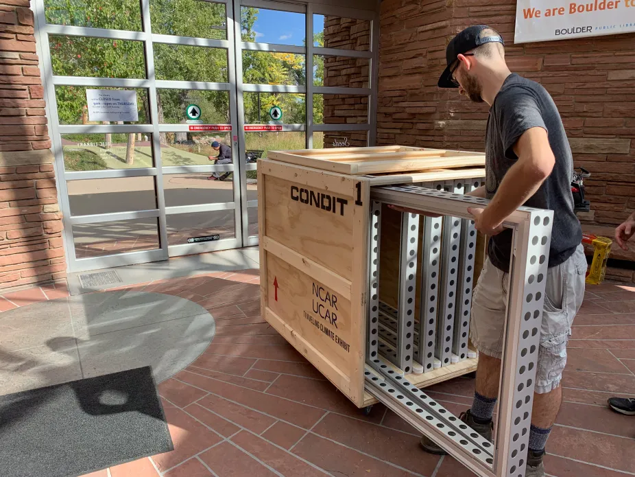 A person packing up one of the Traveling Climate frames into a crate.