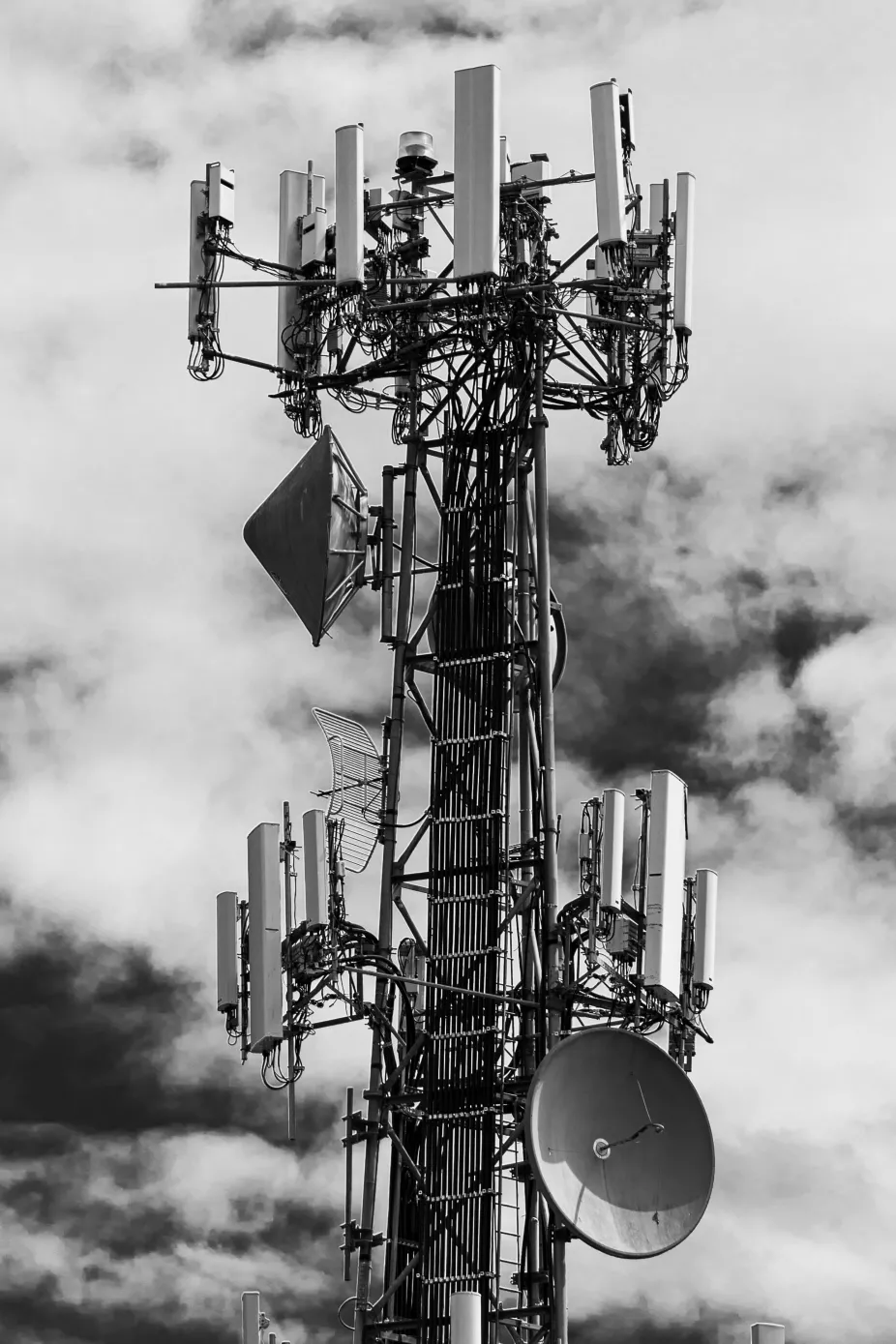 Black and white radio tower with clouds in Harrisonburg, VA on James Madison University's campus.