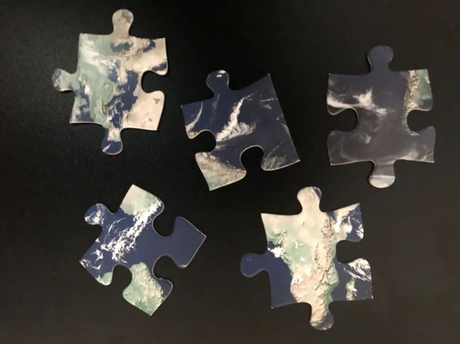 photo of disassembled puzzle pieces each showing individual parts of the Earth system