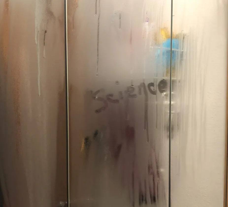 photo of condensation on a bathroom mirror, caused by water vapor changing to liquid water on the cooler surface of the mirror