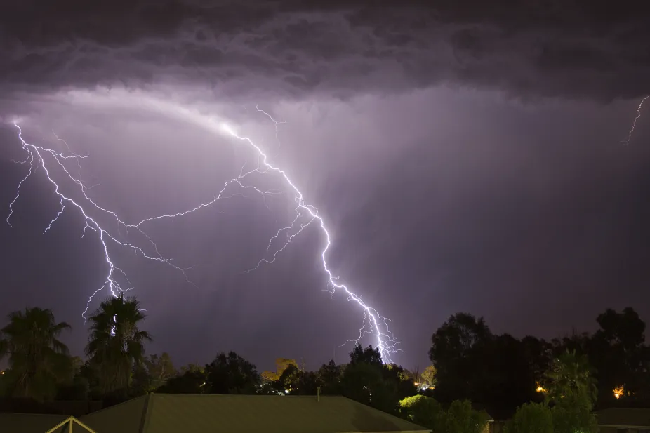 Two lightning strikes at night with buildings in view