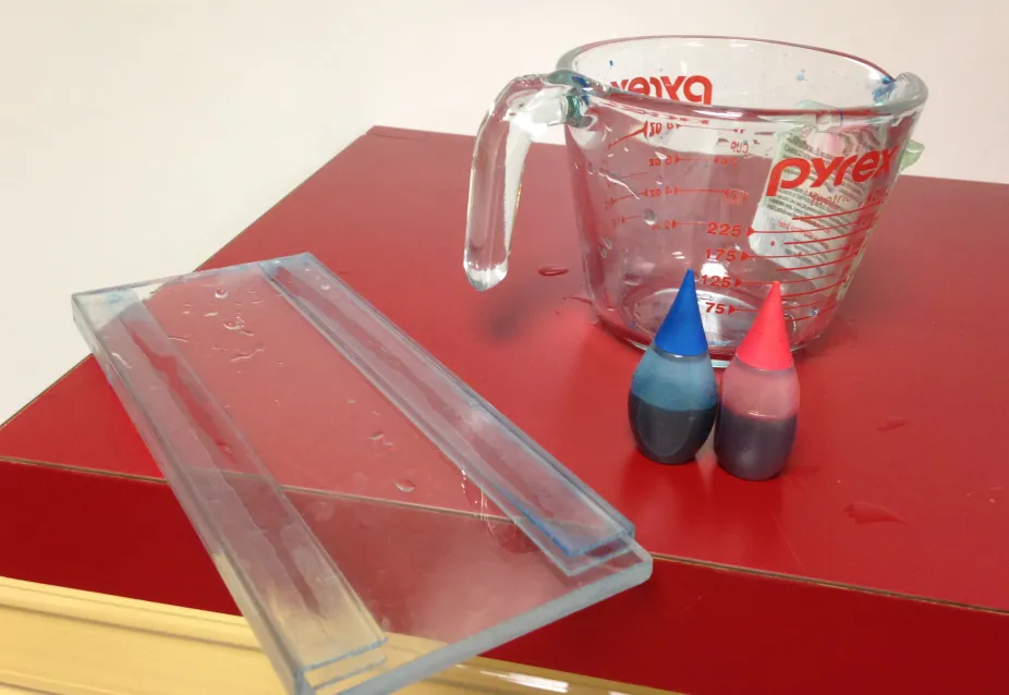 Divider with pyrex measuring cup and blue and red food coloring
