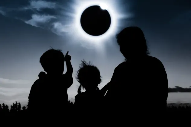 A family looks to the sky during a total solar eclipse.
