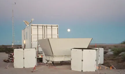 Light biege metal containers with scientific equipment on desert plain