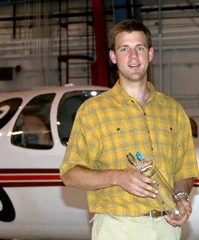 Man standing in front of an airplane inside a hangar