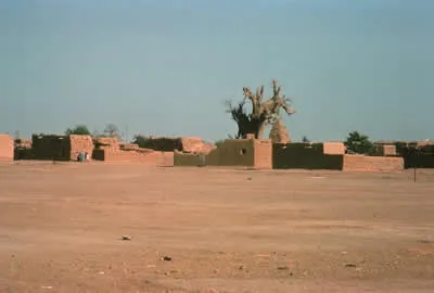 A dry landscape in Ethiopia with blocky, low buildings.