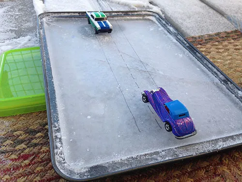 Toy cars on a frozen sheet of ice.