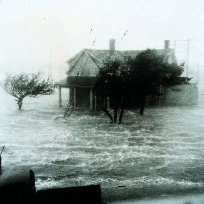 A historic image of water from the ocean flooding into a house near the coast