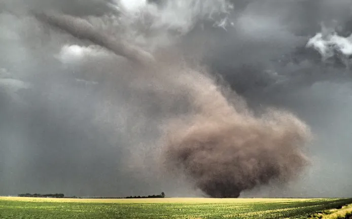 A tornado kicks up dirt and other objects on the ground as it touches down in the plains