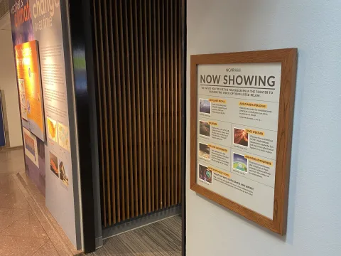 The sign outside the Theater that says "Now Showing" with a list of videos.
