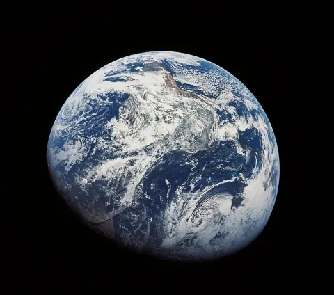 view of Earth from space showing clouds, continents, and ocean