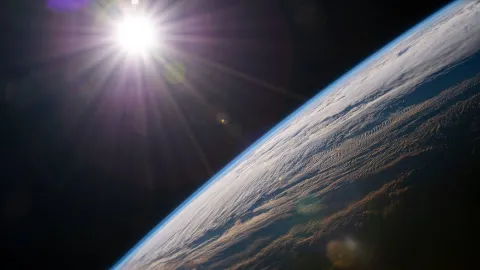 image of the Sun taken from space, with Earth's horizon in the foreground