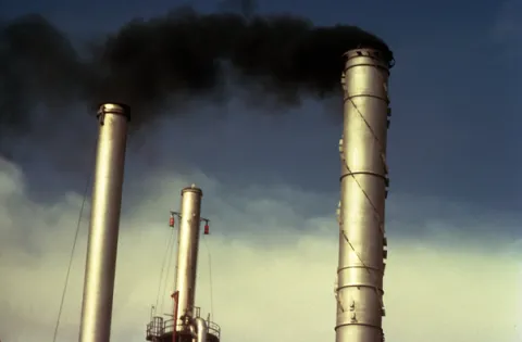 Smokestacks from an oil refinery in Commerce City, Colorado, are shown pumping black smoke into the atmosphere.